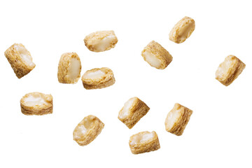 Broken corn pillows with milk cream isolated on white background.