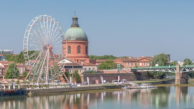 Aerial view of the Garonne River to La Grave Hospital's green dome, timelapse hyperlapse with Saint-Pierre Bridge, Place Saint-Pierre and a ferris wheel on the riverside. Toulouse, France