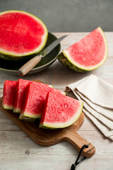 Slices of fresh watermelon on bright rustic wooden table.
