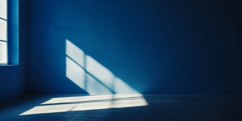 The room is painted in a deep blue with a large window allowing natural light to pour into the space, creating playful shadows on the wall.