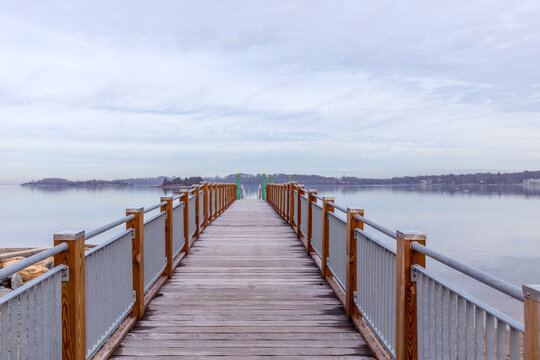 pier leading out to ocean with horizon on cloudy day