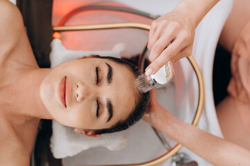 Top‑view scalp spa hair wash on long dark hair in professional salon setting