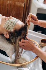 Close‑up spa scalp treatment applying natural scrub with bamboo brush for hair therapy