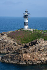 Panoramic photo of Isla Pancha featuring its dramatic cliffs, historic lighthouse, and ocean views, shot from the Ribadeo coastline in the picturesque region of Galicia, Spain