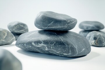 Natural gray rocks stacked in a variety of shapes and sizes against a white background.