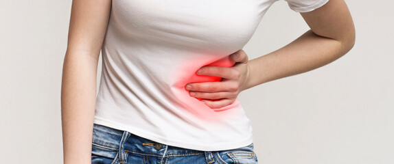 Appendicitis. Problems with the gut and with digestion. Woman in pain holding her stomach on right...