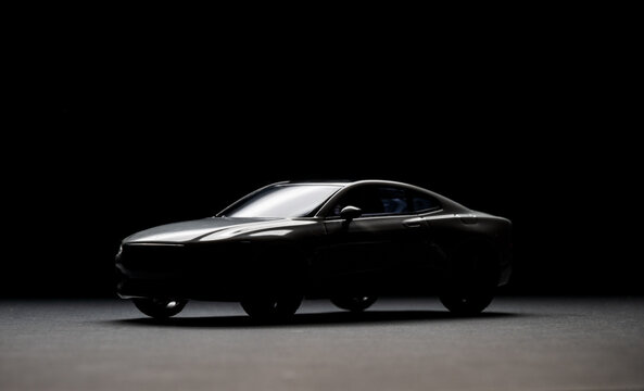 Dark silhouette of a modern sports car.