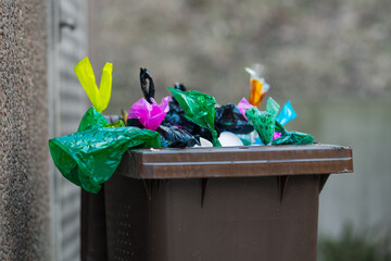 Side view of full outdoor trash bin.
