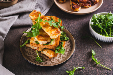 Grilled halloumi and arugula sandwich on a plate on a table