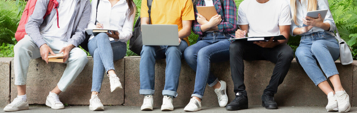 Education concept. Students using laptop and books, resting in university campus - Powered by Adobe
