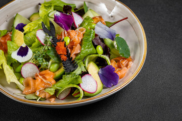 Mediterranean Avocado Salmon Salad with spinach, cherry tomatoes, avocado and red onion dressing. Concept for a tasty and healthy meal. Vegan food
