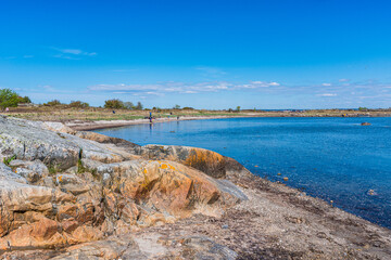 Coastal rocky beach with calm blue waters.
