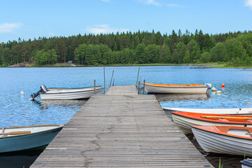 Wooden pier with small boats on lake.