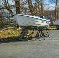 Small motorboat supported by wooden blocks.