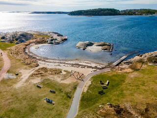 Coastal walking path curving around small bay.