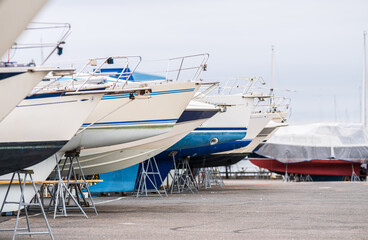 Fototapeta premium Line of moored boats on dry marina platform.
