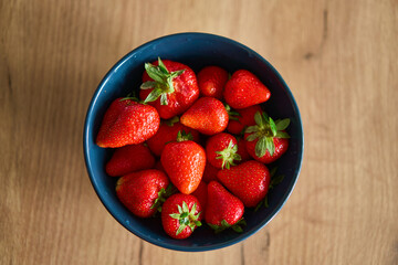 A beautifully vibrant bowl filled with fresh strawberries, showcasing their rich color, sweetness,...