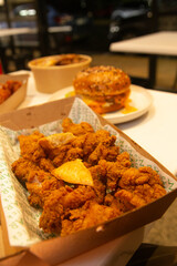 Korean deep dried chicken in paper brown take out box.