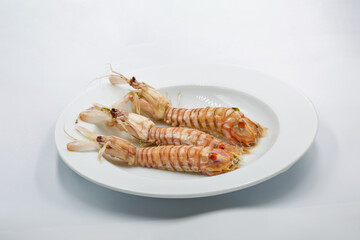 Cooked mantis shrimps on white plate.