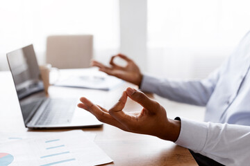 Closeup of Unrecognizable African American Businessman Meditating In Office In Front Of Laptop,...