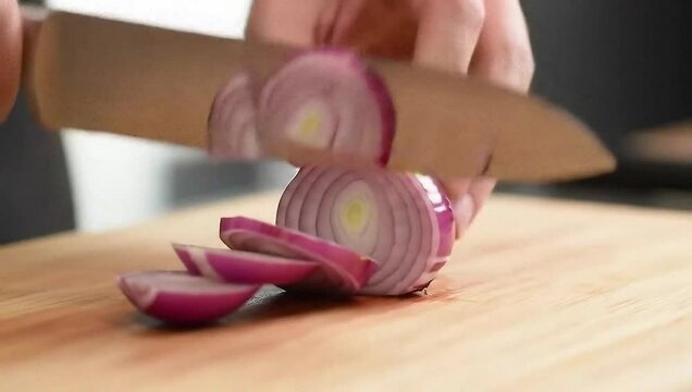 Onion Slice & Sizzle Extreme close-up of a chef slicing a red onion on a wooden cutting board, layers separating in slow motion, crisp sound of the knife, natural light highlighting purple rings.