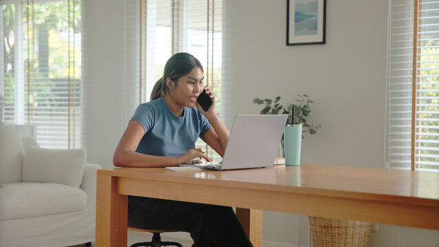 Young adult Gen Z people black asia woman busy phone call work at home using laptop AI search data hybrid workplace. Stock trade IT reskill upskill asian cyber typing coding. Online income tax apply