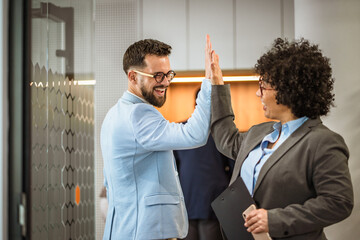 Happy diverse colleagues celebrating success with a lively high five