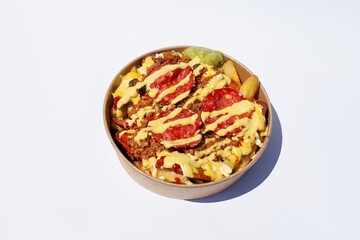salchipapas with salami and avocado - popular latino street food dish in Peru and Colombia - hot dogs and French fries, served with sauce ketchup. Hispanic Latin American cuisine on white background.