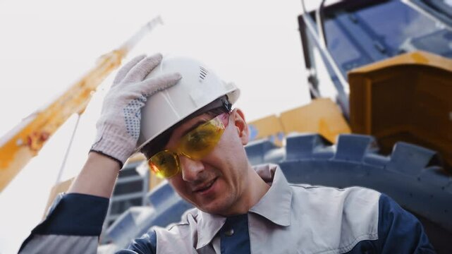 Bulldozer truck driver coal mine in uniform with helmet relax and looking to side. Concept man industrial hard work portrait.