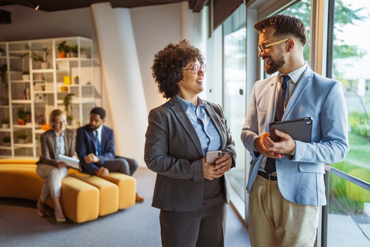 male and female colleagues use tablet together and discuss work