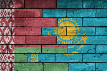 Naklejka premium colourful painted big national flag of belarus and flag of kazakhstan on a massive old brick wall background. concept