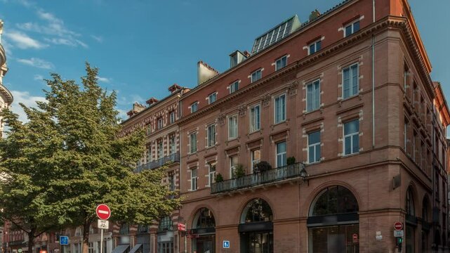 Panorama showing Rue de Metz timelapse in Toulouse, Occitanie, France, with historic facades, shops, cafes, traffic and a blue cloudy sky. Vibrant urban scene in the heart of the city