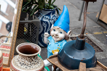 Blue garden gnome figurine and vase are on the flea market
