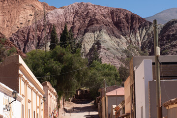 View of a traditional street in Purmamarca, Jujuy, Argentina, with the seven Color Hill in the...