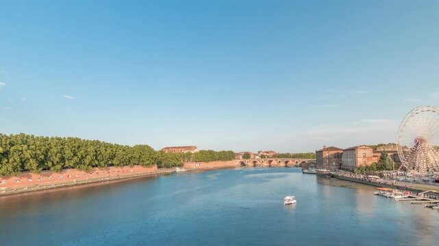 Panorama showing waterfront of Garonne River and Pont Neuf timelapse with Museum of the History of Medicine and ferris wheel in downtown Toulouse, France. Aerial view from Saint Pierre Bridge