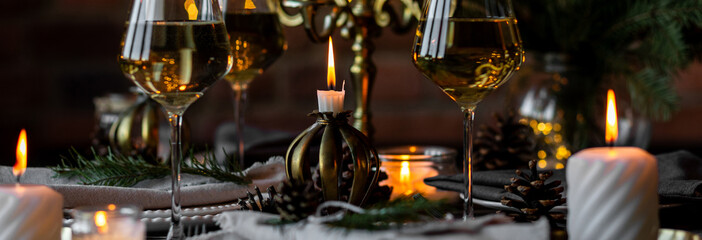 Banner. Elegant decor for Christmas family dinner. Center piece with burning candles, vintage chandelier. Zero waste eco-friendly home decoration, fir tree branches. Cozy atmosphere, wooden furniture