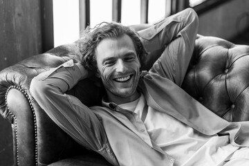 Frontal portrait of young self confident handsome young man in a t-shirt, modern suit or shirt in stylish loft interior, grey walls. Casual closing, fit, slim. Idea for groom male wedding photoshoot