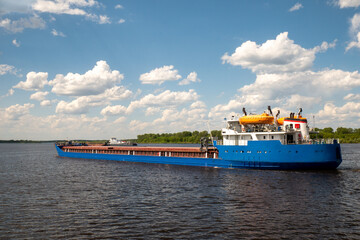 A cargo ship, a cargo ship or an oil tanker, is moving along the river. Logistics and cargo...