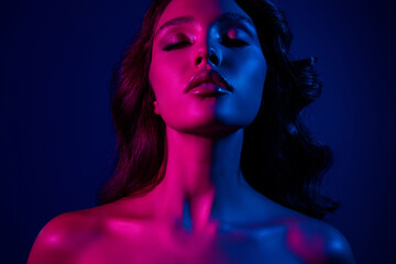 Fototapeta premium Portrait of a stunning woman with neon lighting in pink and blue hues conveying elegance, beauty, and modern style