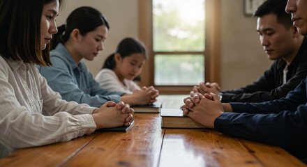 Group of People Praying Together At Table With Closed Eyes in a Peaceful Scene