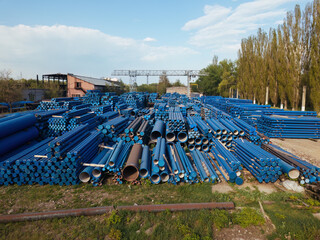 Stack of cast iron pipes in loading area waiting for transportation, drone aerial view