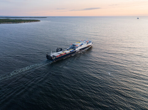PALDISKI, ESTONIA &ndash; JUNE 7, 2025: A drone view of a DFDS Ro-Ro cargo ferry, transporting trucks and trailers, sails on its route in the Baltic Sea near the port of Paldiski at sunset.