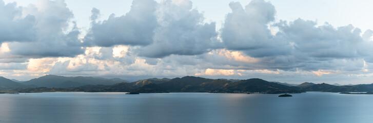 Paisagem panorâmica com mar, montanhas e céu.