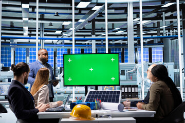 Solar panels plant manager uses green screen monitor to present manufacturing strategies to investors. Photovoltaics factory executive uses mockup display to show data to shareholders