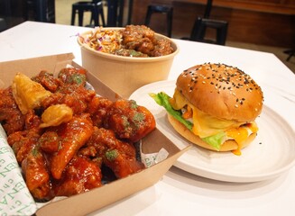 Korean deep dried spicy red chicken sauce in a paper takeaway box.