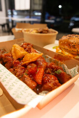 Korean deep dried spicy red chicken sauce in a paper takeaway box.