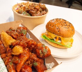 Korean deep dried spicy red chicken sauce in a paper takeaway box.