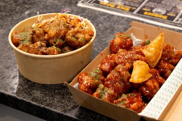 Korean deep dried spicy red chicken sauce in a paper takeaway box.