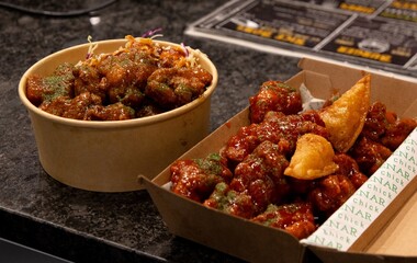 Korean deep dried spicy red chicken sauce in a paper takeaway box.