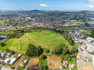 Urban landscape of Mount Roskill, Auckland, Auckland, New Zealand, featuring a busy highway, residential homes, and Mt Roskill volcano